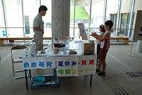 施設のロビーで職員が来場者に展示内容を説明している写真