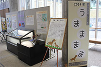 馬のイラストが描かれたパネルやホワイトボードが設置された企画展の写真