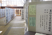 壁に多くの作品が貼られている書道展の小学生の部のブースの入口の写真