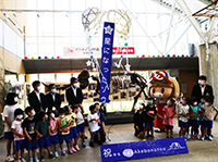 アケボノゾウの標本と着ぐるみの横に整列して並ぶ園児たちの写真