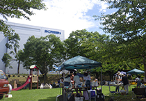 屋外に設置された赤い色の滑り台と緑色のテントの写真