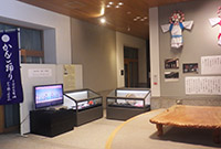 展示室内で複数の展示ケースと解説パネルが並んでいる様子の写真