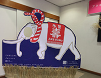 赤色と白色のしめ縄を首に巻いた白いゾウのイラストのパネルの写真