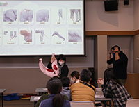 プロジェクターの前で説明をしている女性の写真