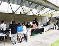 屋外で机を並べマルシェを開催している様子の写真