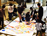 画用紙の上でフロッタージュを楽しむ児童たちの写真