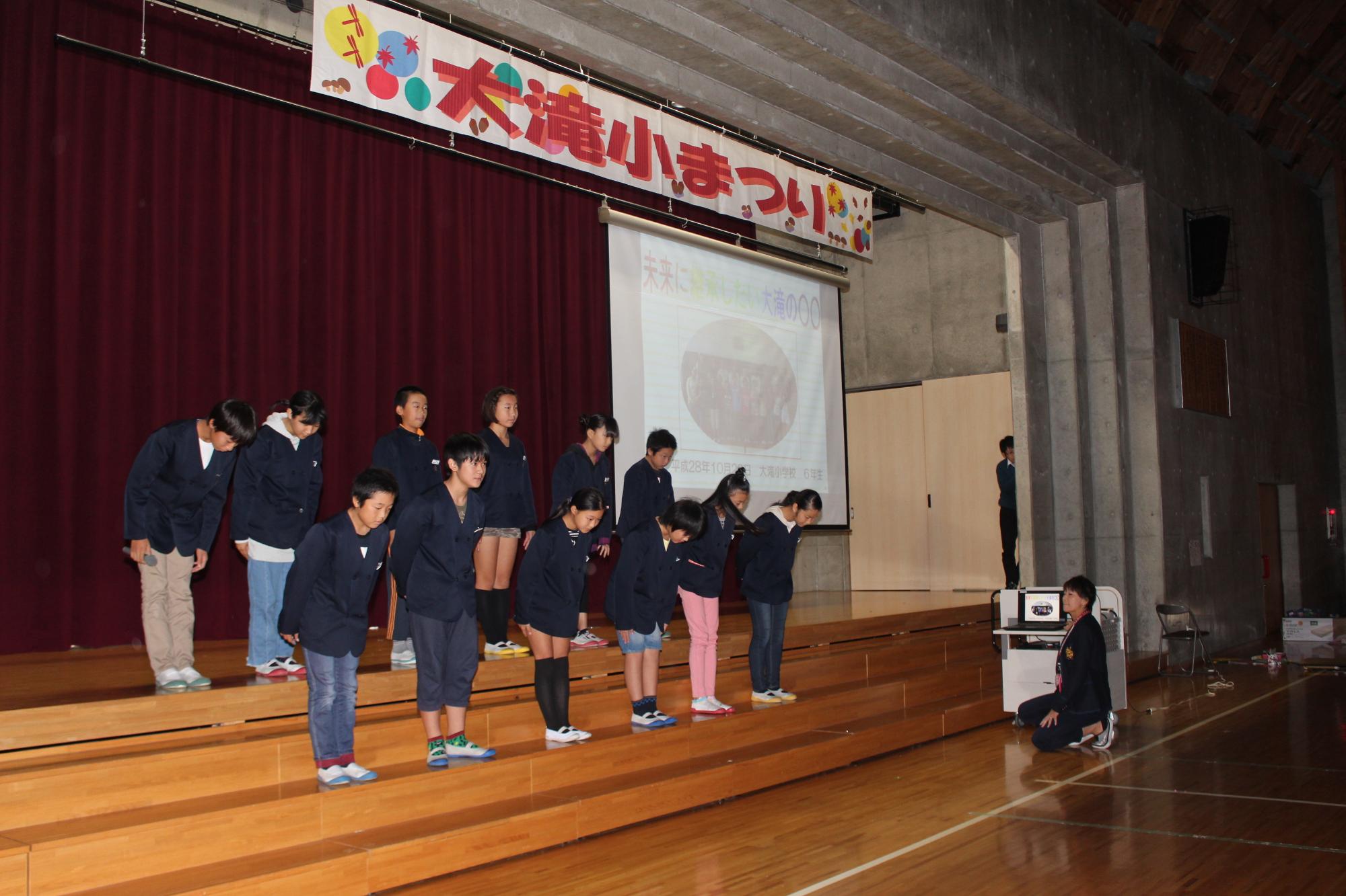 舞台でお辞儀をしている児童たちの写真