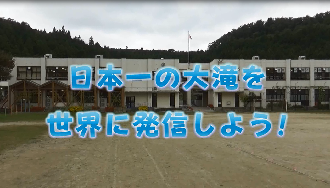 校舎の写真の上に青で「日本一の大滝を世界に発信しよう！」と書かれた写真（YouTubeへリンク）