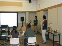 公民館の会議室で職員と参加者が前方の資料を見ながら説明を受けている写真