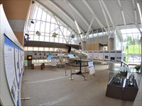 室内に複数のホワイトボードが囲むように並べられ様々な作品が展示されている様子の写真