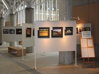 窓際に作品が貼られたホワイトボードが並んでいる展示風景の写真