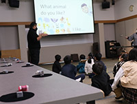 研修室で講師がスクリーンを使って英語の問いかけをしている写真