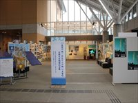 室内に大小様々なサイズのパネルや作品が飾られている記念展の全体の写真