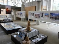 ホワイトボードに様々な写真が飾られその前に立体作品が設置されている様子の写真