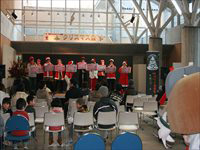 ホールのステージ上で参加者たちが並んで発表や演奏を行っている写真