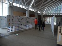 大型のパネルに数十枚の年賀状が展示されている様子の写真