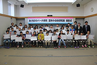 自由研究の表彰式で表彰状を掲げて整列して記念撮影をする子供たちの写真