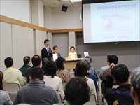 会議室で講師と参加者が前方のスクリーンを見ながら説明を聞いている写真