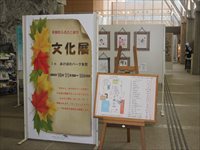 公共施設のロビーで文化展の案内パネルと展示作品を紹介している様子の写真