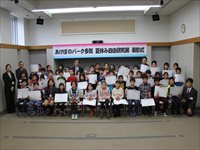 会議室で参加者全員が前に並んで記念撮影をしている写真