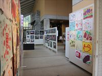 通路沿いに写真や作品を掲示した展示スペースの様子の写真