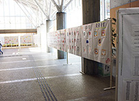 通路沿いに作品やパネルを連続して展示している様子の写真