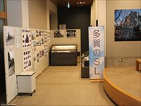 多賀のSLと大きく書かれたパネルと壁に貼られている展示品の写真