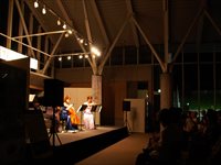 屋内ステージで演奏者たちが照明に照らされて演奏している写真