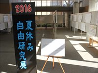 黒地に青文字で夏休み自由研究と書かれたパネルがホールに置かれている写真