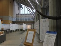 ホールに整列したパーテーションが並び展示品が飾られている写真