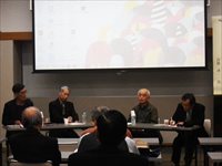 講義室で複数の講師が並び参加者に向けて討論を行っている座談会の写真