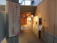 赤字で神あかりフォトコンテスト作品展と書かれたパネルが入口に置かれている写真