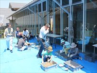 屋外の建物前で親子が道具を使って発掘体験をしている様子の写真