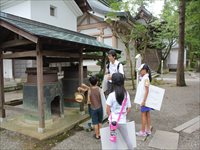 神社の境内を児童たちが訪問し、自由研究のための学習をしている様子の写真