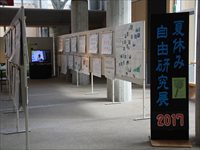 黒地に青文字で「夏休み 自由研究展 2017」と書かれた入口のパネルの写真