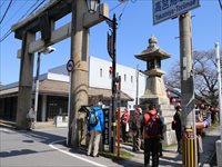 神社の鳥居前で参加者たちが集まり見学をしている様子の写真