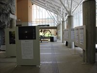 ガラス張りのホールにパーテーションが置かれ、展示物が貼ってある様子の写真