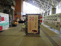 広いホールの中央に大きなパーテーションが置かれ、周りにも多くの展示物が貼られている写真