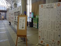 パーテーション一面に細かい文字が書かれた用紙が貼られている写真