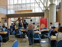 施設のロビーでテーブルを囲んで参加者たちがカロムをしている写真