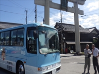 施設の前で送迎用のバスに乗り降りする参加者たちの様子を写した写真