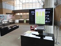 ロビーに展示品が飾られモニターに説明が映し出されている写真