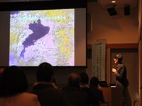 講義室で講師がスクリーンに映した地図を指しながら解説している講座の写真