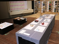 黒い台に灰色の布が敷かれて上に展示物が乗っている写真