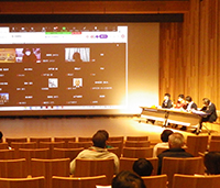 講堂でスクリーンを前に登壇者が並び発表をしている写真