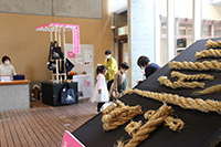 博物館ロビーの骨格展示を近くから写し奥に来場者が集まっている写真