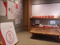 展示室の壁面に資料と展示台が並べられている様子の写真