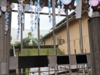 屋外通路に装飾と展示パネルが吊るされている様子の写真