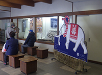 館内入口付近に設置されたパネル前で来館者が通路を歩いている写真