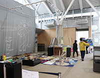 ロビーの壁面にチョークアートが描かれ工作道具が並ぶイベント準備中の写真